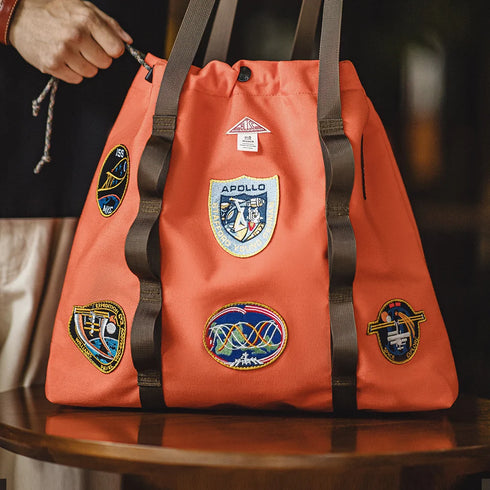 Orange bag with patches on a wooden surface